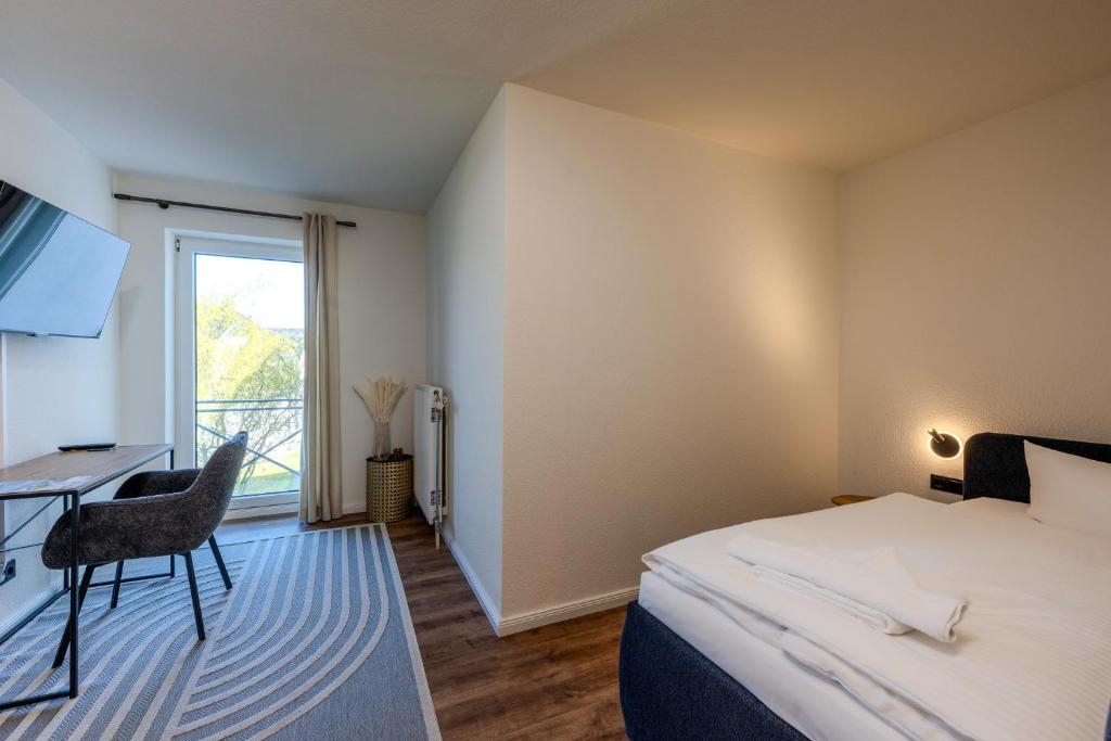 a bedroom with a bed and a desk and a window at Johouse Zingst Johouse Zimmer 05 in Zingst