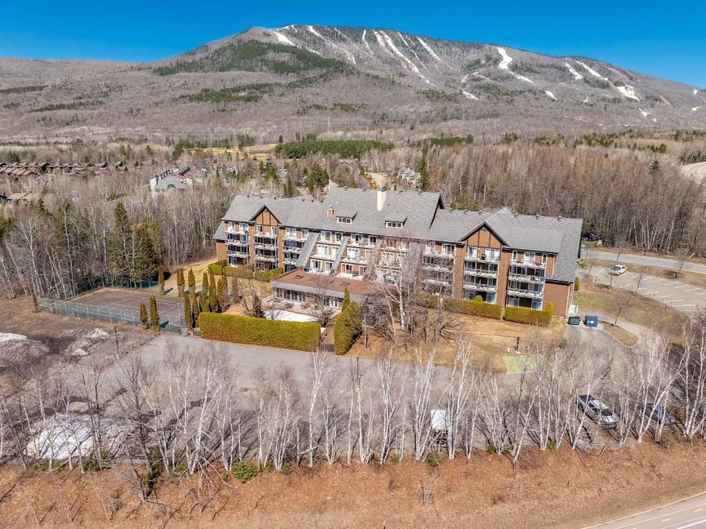 an aerial view of a large house with a mountain at Modern Condo with Pool - Le Rendez-Vous in Beaupré