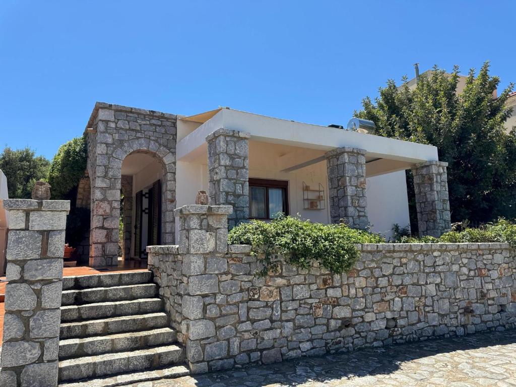 a stone wall in front of a house at Jassemi Studio in Mavrovouni