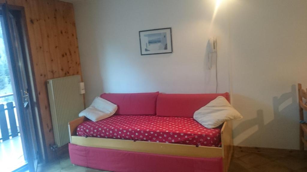 a couch sitting in the corner of a room at Rododendro Apartment in Passo San Pellegrino