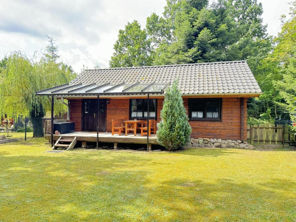 a small wooden cabin with a porch in a yard at Ferienhaus 'am Eulennest' in Jabel