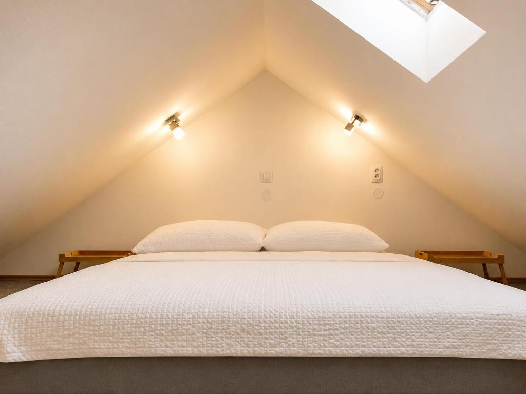 a bedroom with a white bed with two pillows at Symbiola River Apartments in Děčín