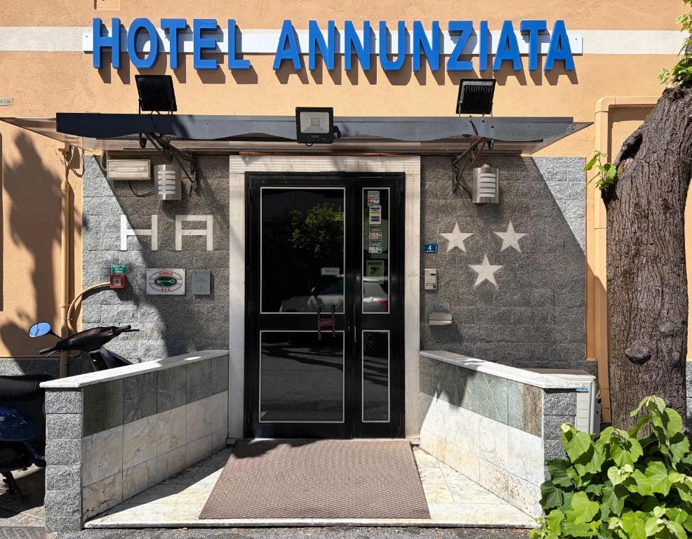 a hotel entrance with a door with an american flag at Hotel Annunziata in Massa