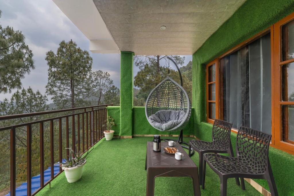 a balcony with two chairs and a swing at Hotel Elegant Dreamscape Kasauli by Splendid Retreat Hotels in Kasauli