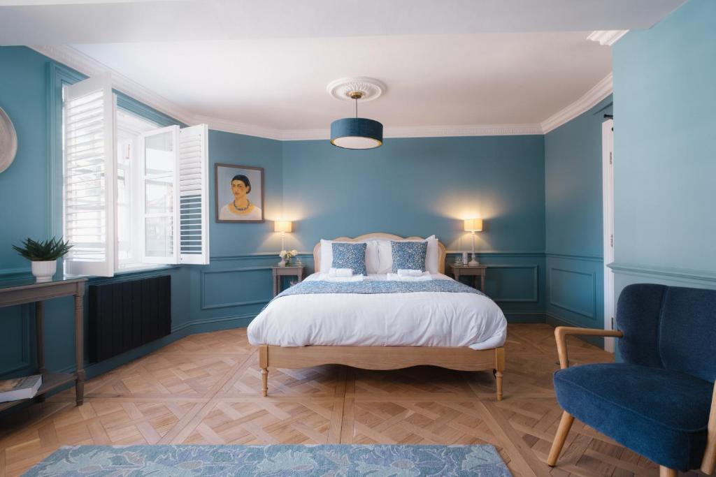 a blue bedroom with a bed and a chair at Lowcross House in Whitchurch