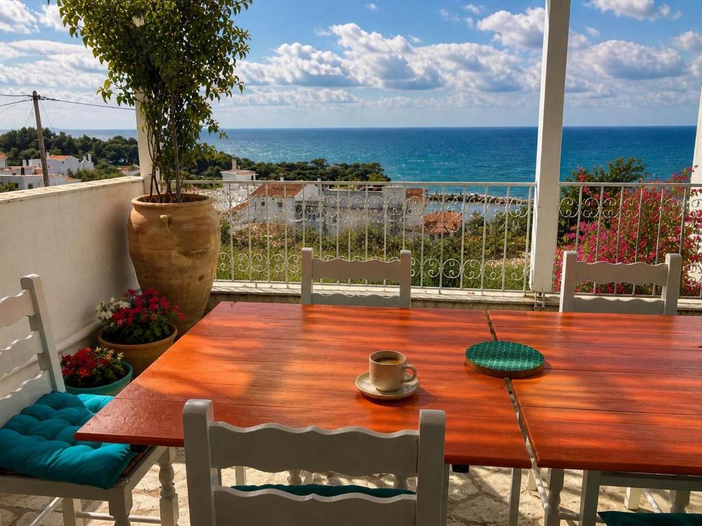 a wooden table and chairs with a view of the ocean at Casa Spartines in Votsi