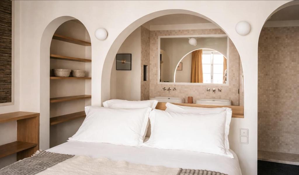 a bedroom with a bed and a mirror at Hotel Habituel in Paris