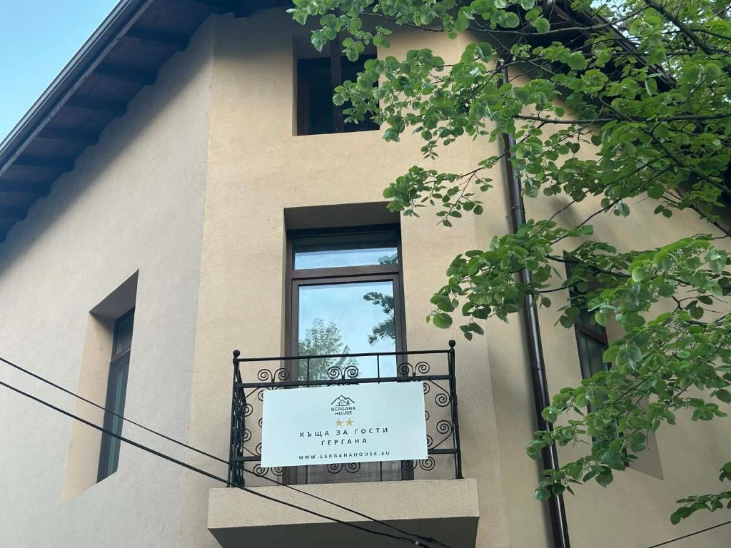 a sign on the side of a building with a window at Къща за гости Гергана in Troyan