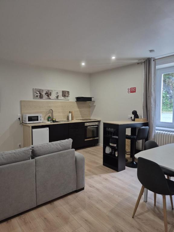 a living room with a couch and a kitchen at Doré in Carhaix-Plouguer