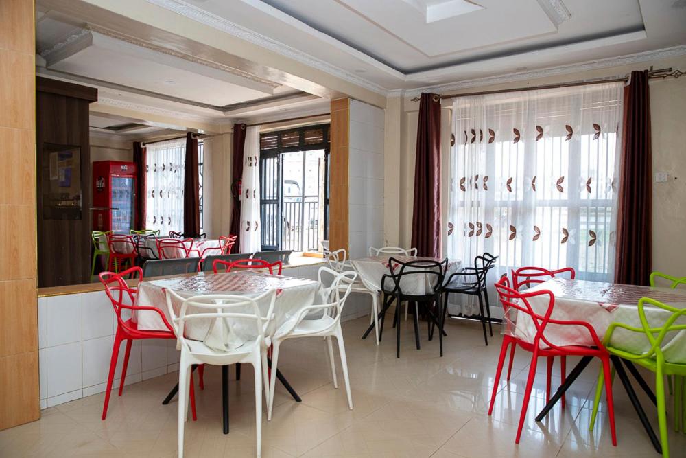 a dining room with red and white tables and chairs at ST Augustine Hotel Ltd in Kisumu