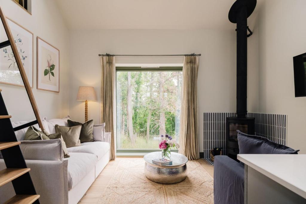 a living room with a white couch and a fireplace at The Old Workshop, Combrook in Combrook