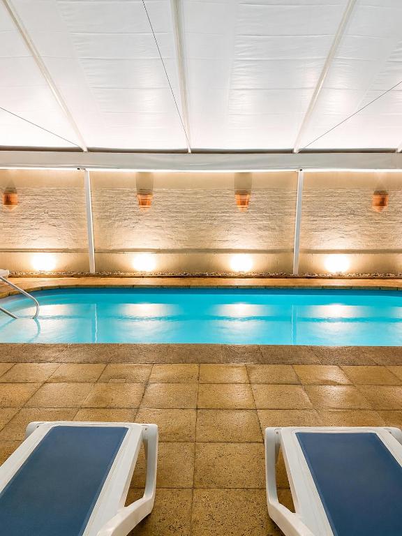 a swimming pool with two beds in a room at Hotel Ajax in Punta del Este