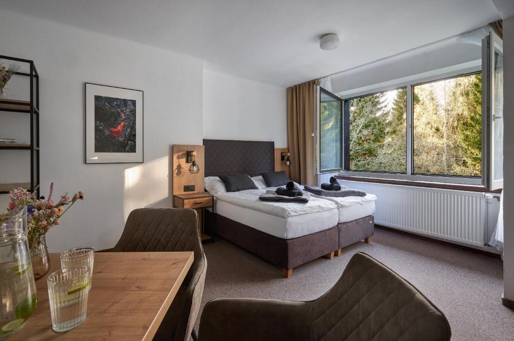 a bedroom with a bed and a table and a couch at Hotel Popel in Stachy