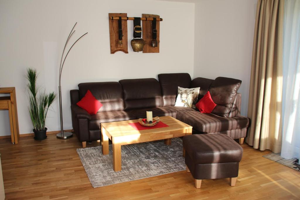 ein Wohnzimmer mit Ledersofa und Couchtisch in der Unterkunft Allgäu Vital Oberstaufen inkl Oberstaufen Plus Card in Oberstaufen