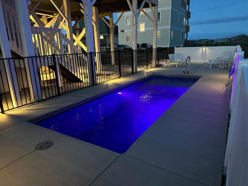 a swimming pool with purple lights on a house at Genesis On The Water - Semi-Oceanfront - Hot Tub - Pool in Rodanthe