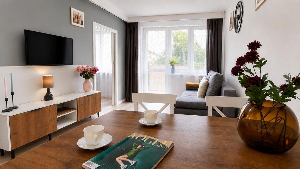 a living room with a table and a tv at Albatros Apartment Stogi in Gdańsk