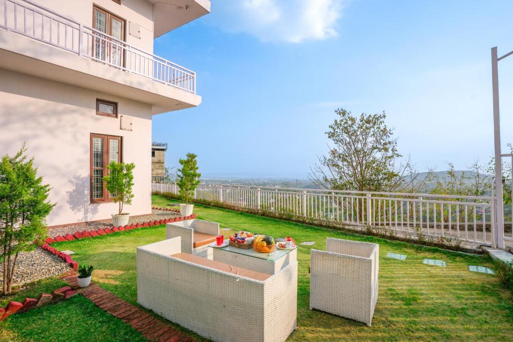 a balcony of a house with a table and chairs at Adviga by The StayCationer in Dehradun