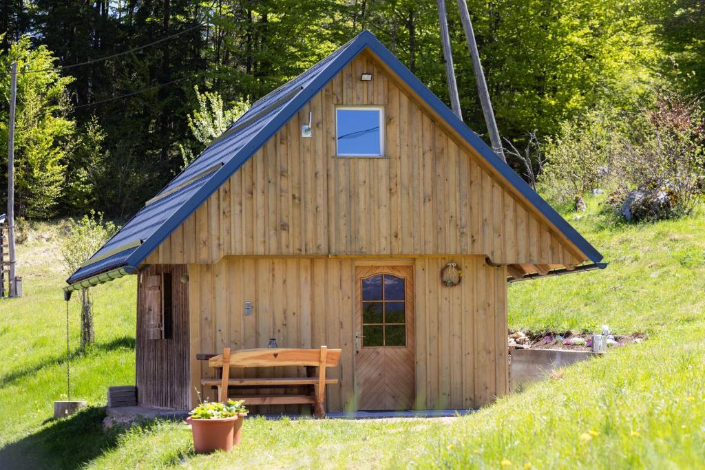 a small wooden shed with a blue roof at Hiška Janko in Bohinjska Bistrica