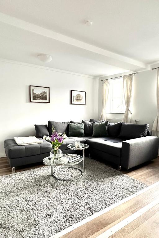 a living room with a black couch and a table at Das Stader Zuhause in Stade