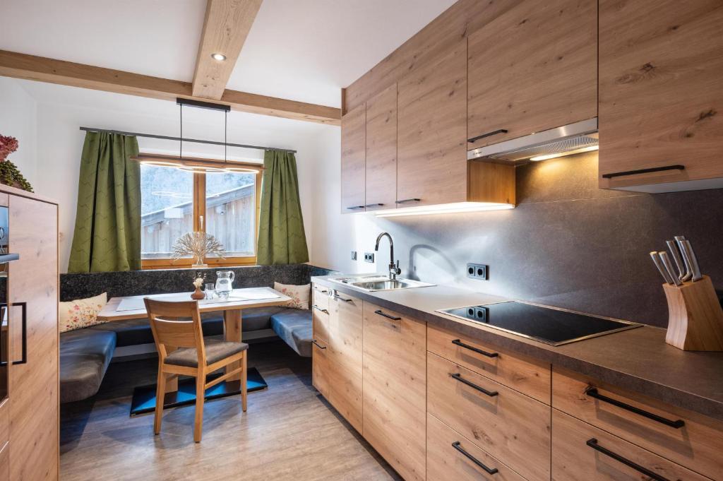 a kitchen with wooden cabinets and a table with a sink at Walcherbäck in Fieberbrunn