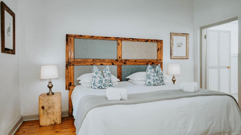 a bedroom with a large bed with blue and white pillows at Cottage 1 at River Bend in Graaff-Reinet