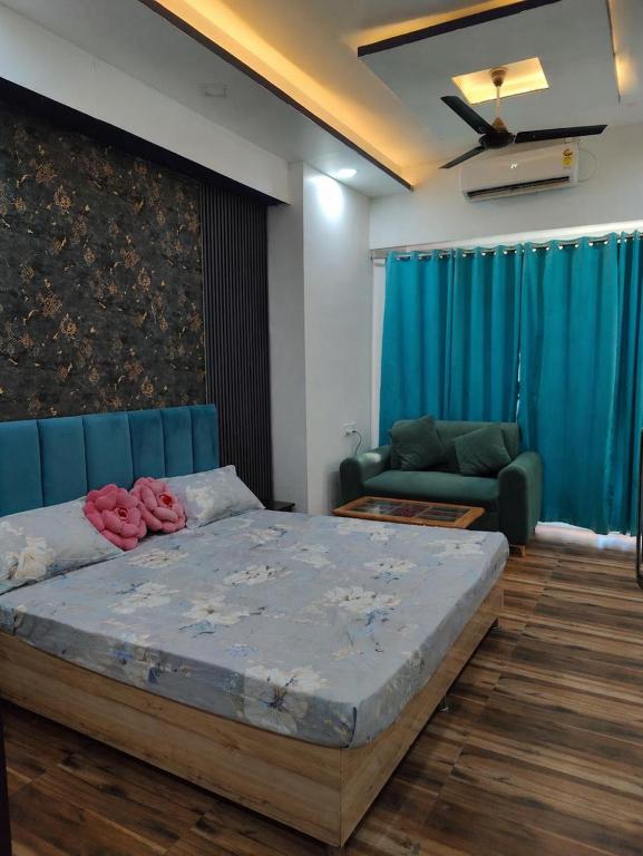 a bedroom with a large bed and a couch at Arista Stay I Studio Room I Sec-4 Greater Noida in Noida