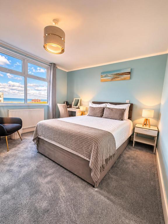 a bedroom with a bed and a desk with a computer at The Lyncroft in Newquay