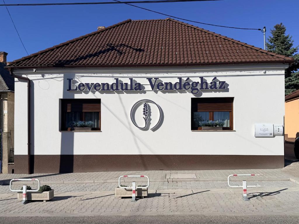 a white building with a sign on it at Levendula Vendégház in Győr