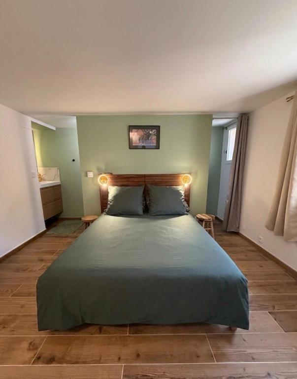 a bedroom with a large bed with lights on it at Studio vert à 400 m de la plage in Le Pradet