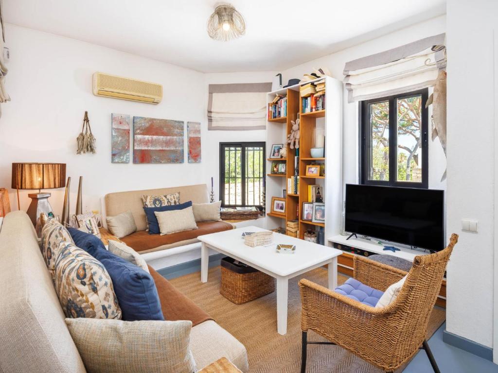 a living room with a couch and a tv at Villa Sunshine in Vale do Lobo