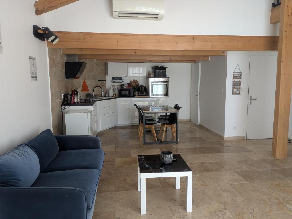 a living room with a blue couch and a table at Maison moderne et lumineuse in Cavaillon