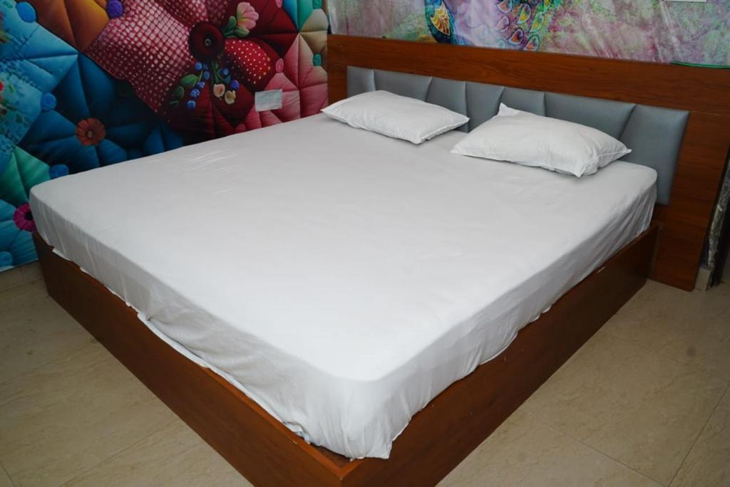 a bed with white sheets and pillows in a room at Hotel park view in Bathinda