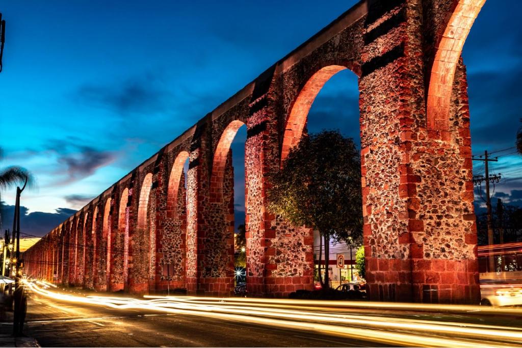 a bridge over a street at night at Hostal Queretaro LOMAS M in Laborcillas