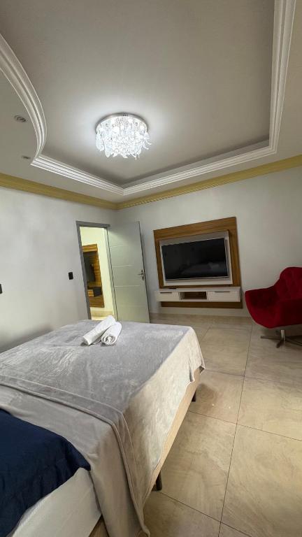 a bedroom with a bed and a flat screen tv at Izze Home in Palmas