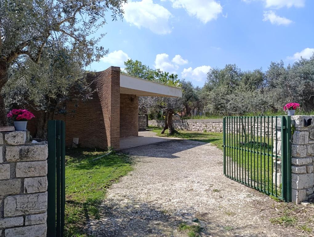 a brick building with a gate and a stone wall at Home among the olive trees in Tivoli