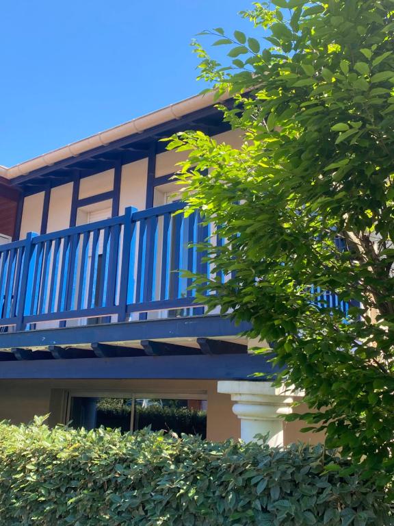 a blue balcony on a building with a tree at Domaine du Malda Côte Basque in Anglet