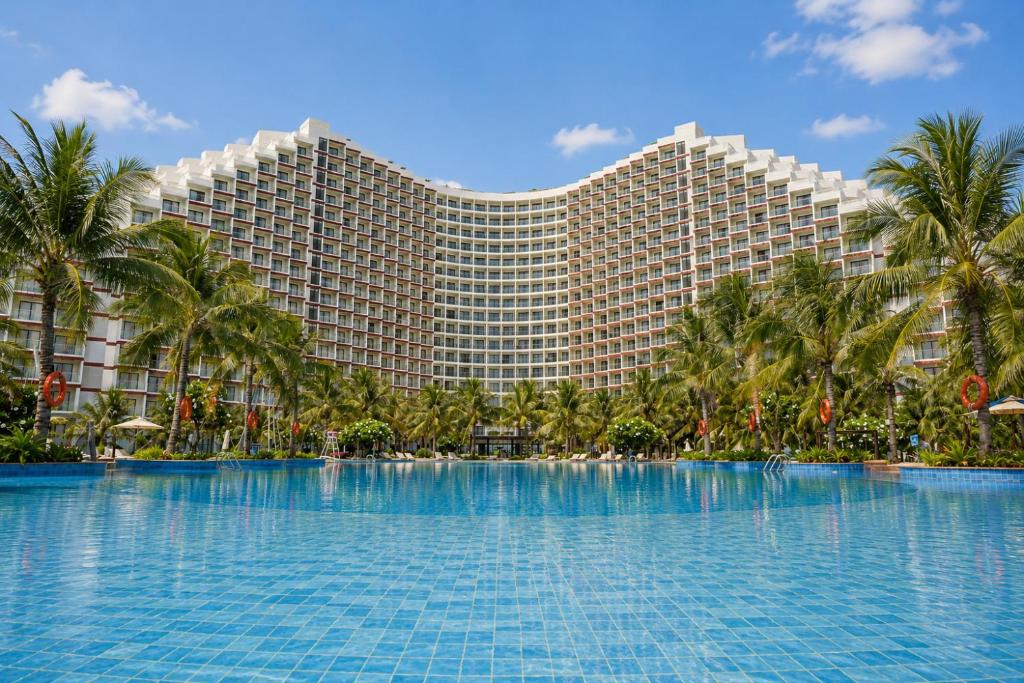 a large resort building with a large swimming pool at Lagoon Beach Of The Arena Cam Ranh - Free room upgrade in Cam Ranh International Airport