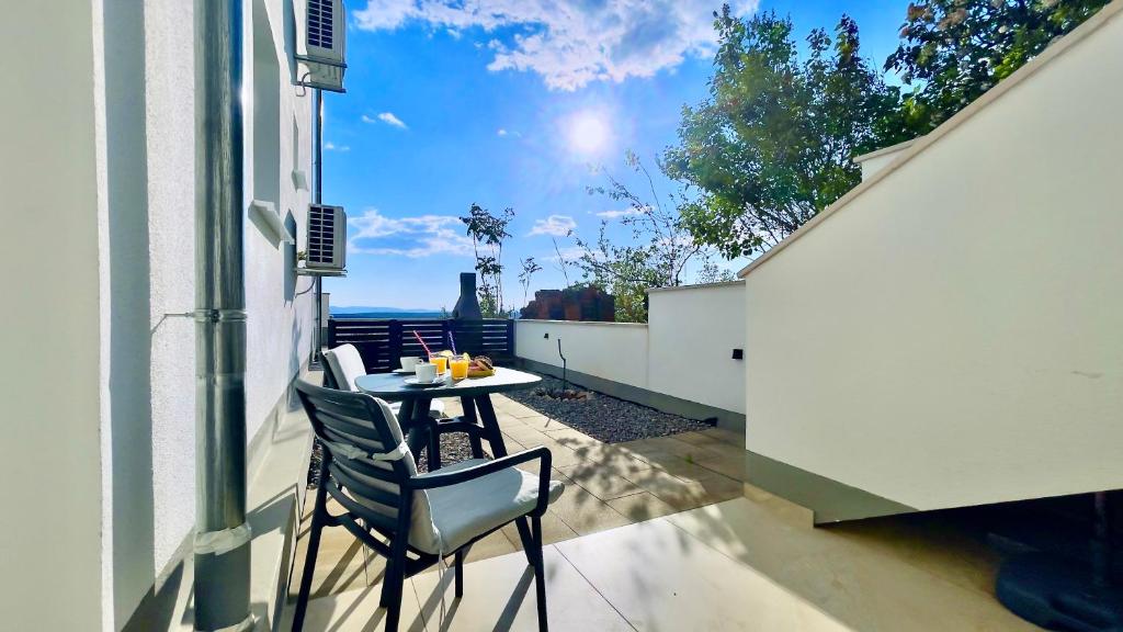 a patio with a table and chairs on a balcony at Mini Lea in Jadranovo