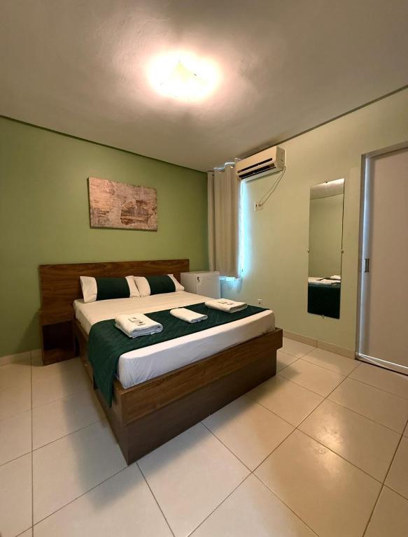 a bedroom with a bed with a green wall at Domus Hotel Rio Verde - Parauapebas in Parauapebas