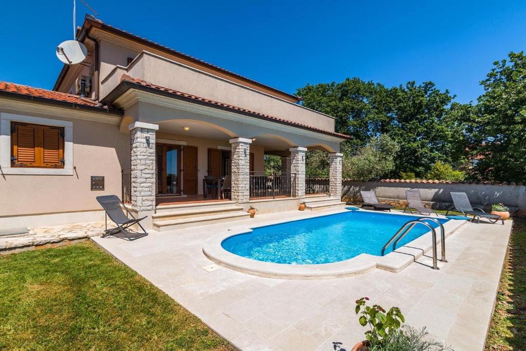 a house with a swimming pool in a yard at Villa Antonela in Divšići