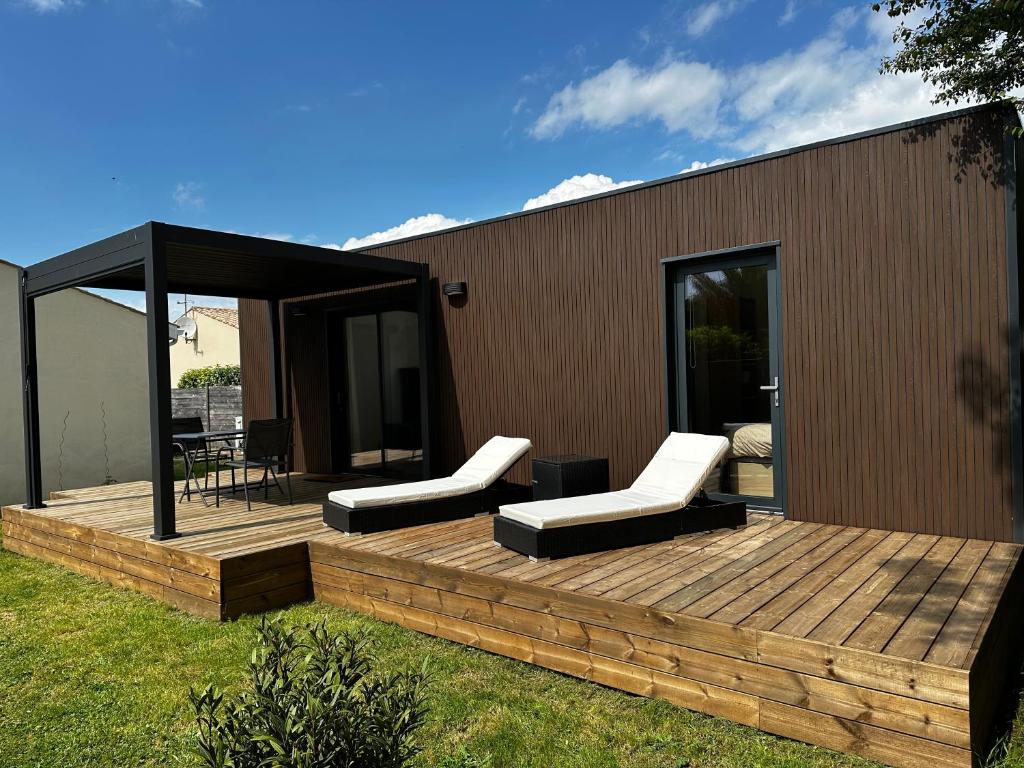 a wooden deck with two lounge chairs on it at Lilikaz in Saint-Laurent-de-la-Prée