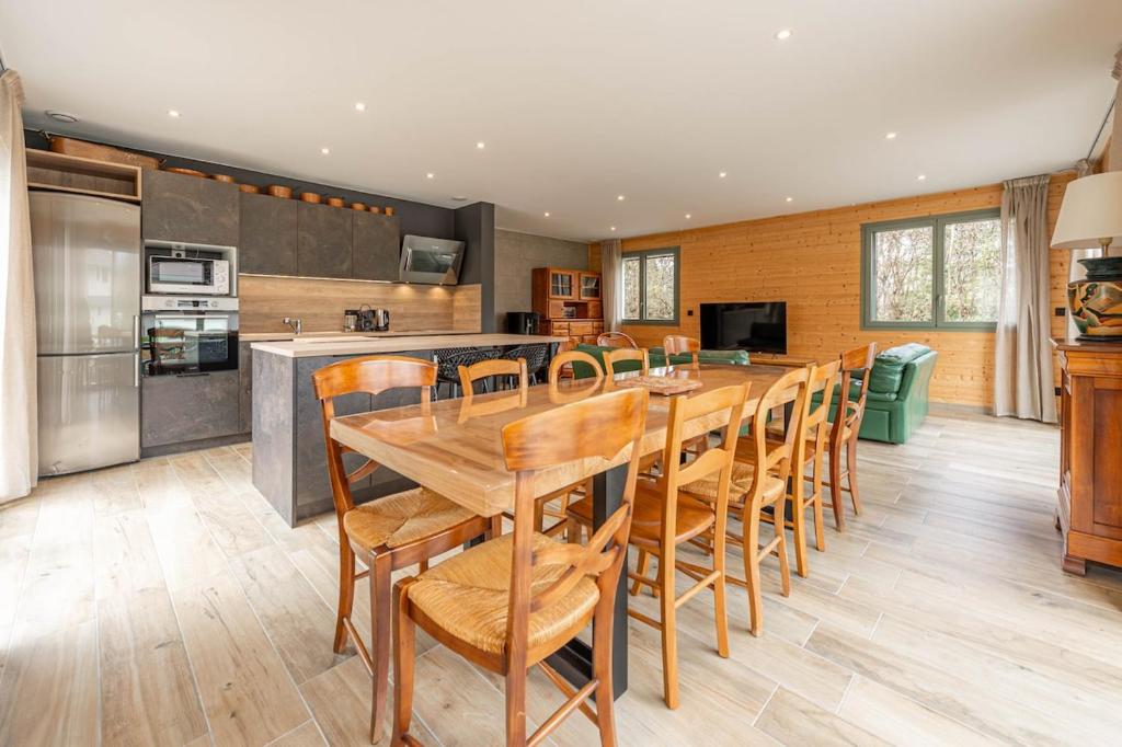 a kitchen with a long wooden table and chairs at Villa Mareyland Saint-Jorioz, in Saint-Jorioz