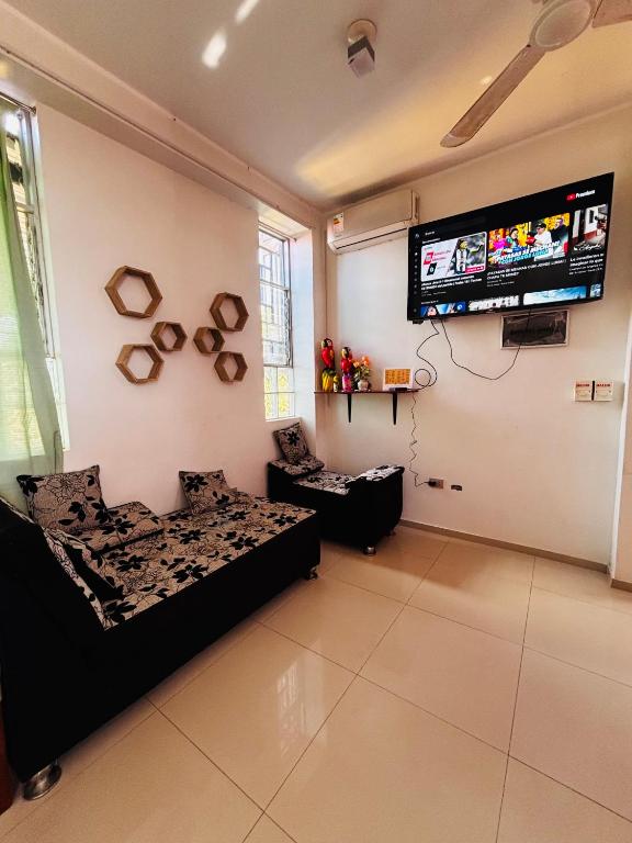 a living room with a bed and a flat screen tv at Flat pucallpa in Pucallpa