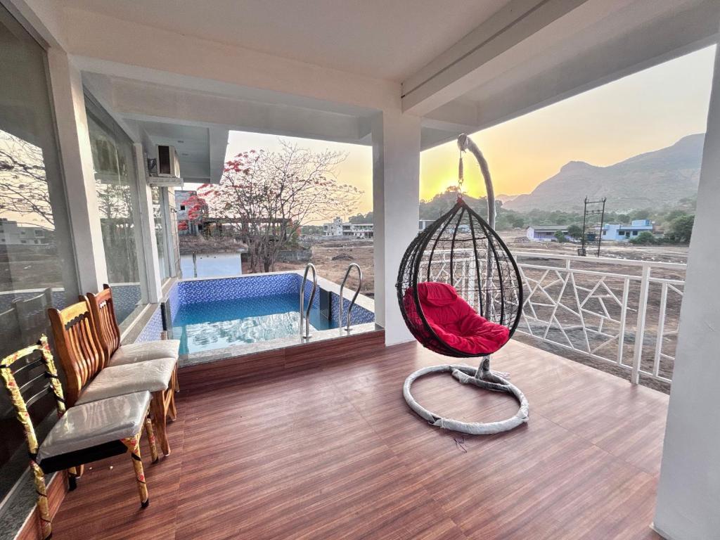 a room with a swing and a swimming pool at Avera luxurious stay in Igatpuri