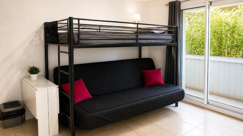 a black bunk bed with a couch in a room at Dramont Getaway in Saint-Raphaël