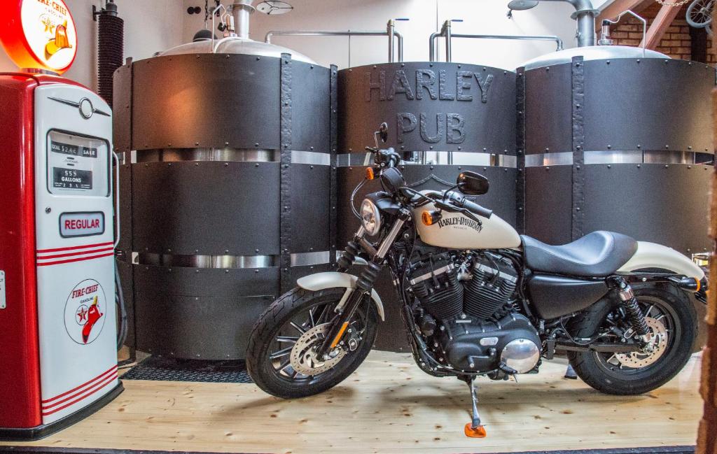 una motocicleta estacionada en un garaje junto a barriles en Penzion Harley Pub, en Otrokovice