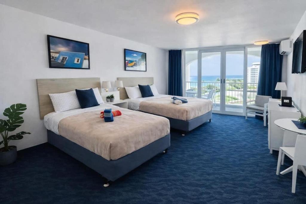 a hotel room with two beds and a balcony at Relaxing Ocean View Condo by the Beach in San Juan