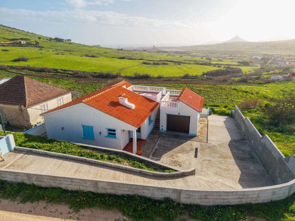 a white house with an orange roof in a field at Sailor House - By Wehost in Porto Santo