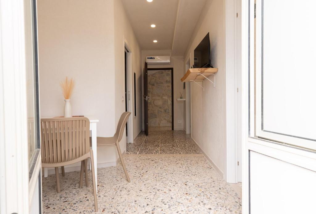 a hallway with a table and chairs and a door at Civico Dodici in Modica