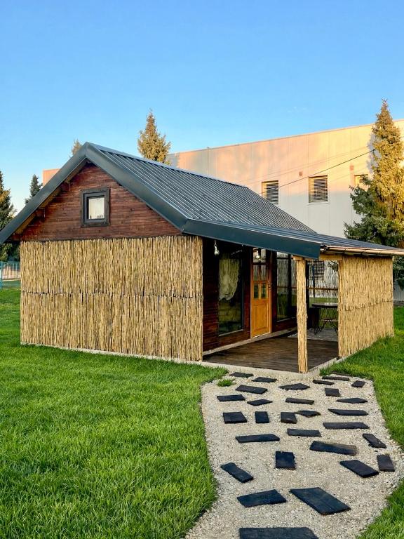 a barn with a black roof and a walkway at House by the river in Ptuj